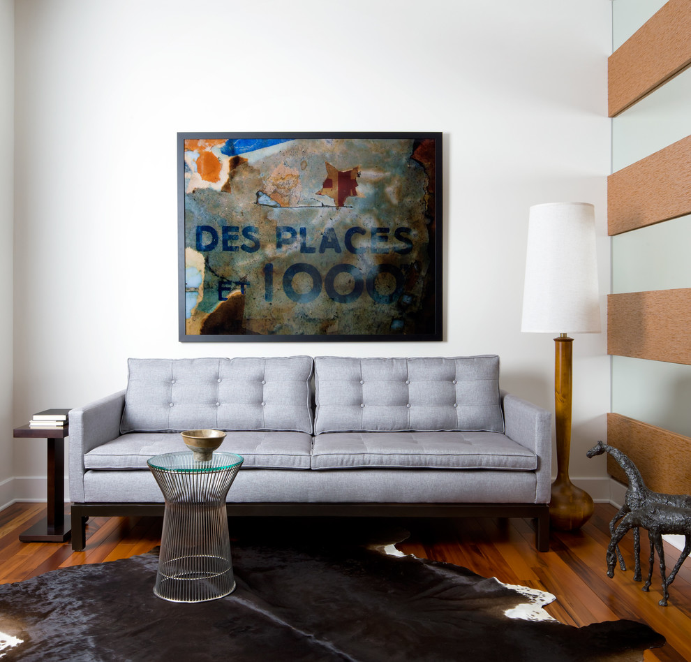 Imagen de salón para visitas actual pequeño sin chimenea con suelo de madera en tonos medios y paredes blancas