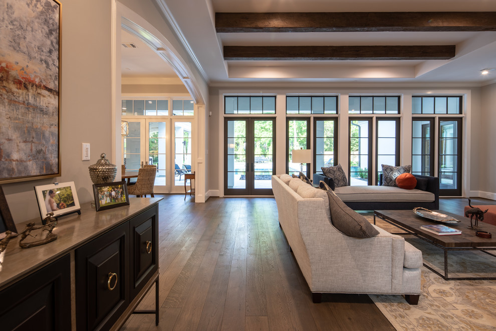 Geräumiges, Offenes Klassisches Wohnzimmer mit grauer Wandfarbe, dunklem Holzboden und braunem Boden in Houston