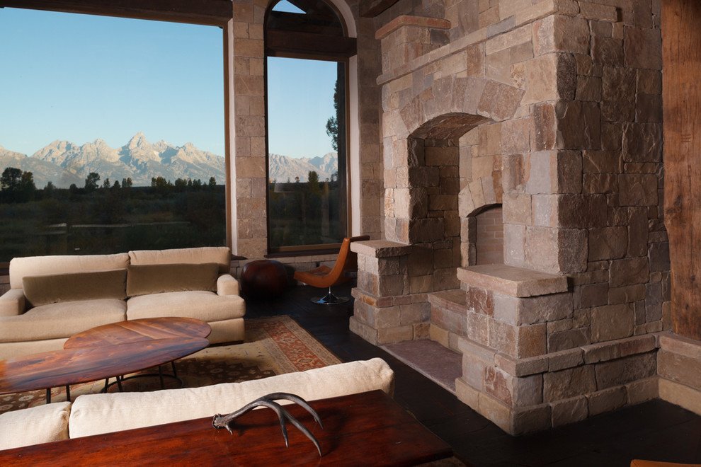 Свежая идея для дизайна: гостиная комната в стиле рустика с фасадом камина из камня - отличное фото интерьера