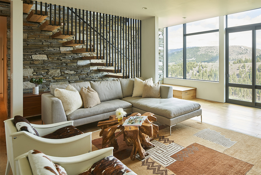 Trendy medium tone wood floor and brown floor living room photo in Other with beige walls