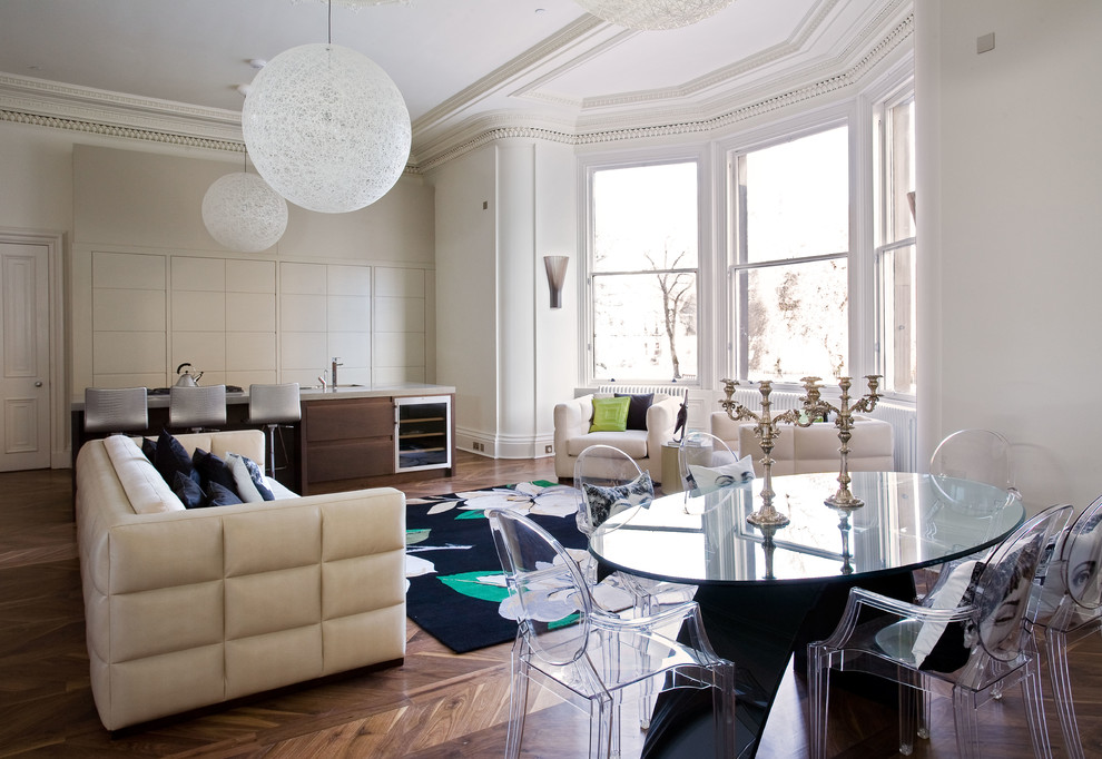 Cette image montre un salon design ouvert avec parquet foncé, une salle de réception et un mur blanc.