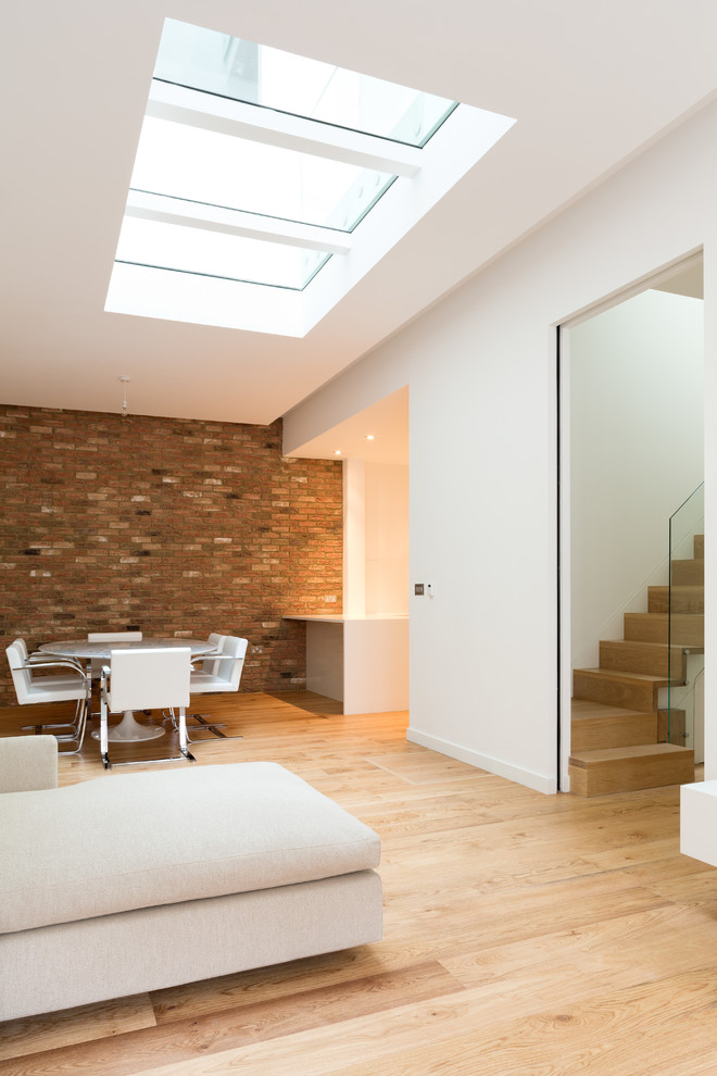 Ejemplo de salón abierto contemporáneo de tamaño medio con paredes blancas, suelo de madera en tonos medios y suelo marrón