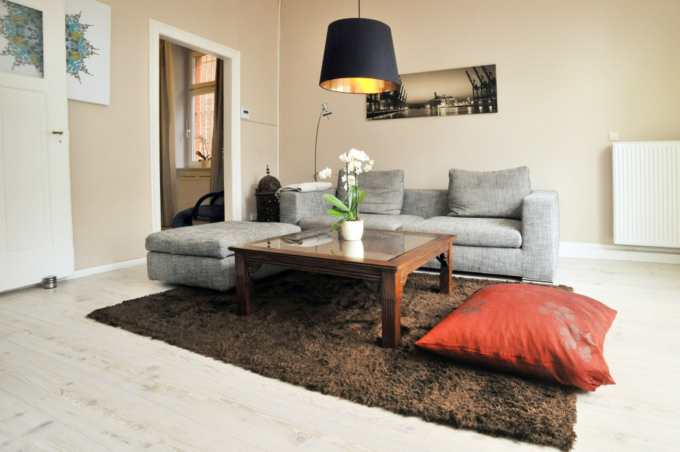 На фото: двухуровневая гостиная комната среднего размера в стиле модернизм с коричневыми стенами, полом из ламината, отдельно стоящим телевизором, белым полом и обоями на стенах