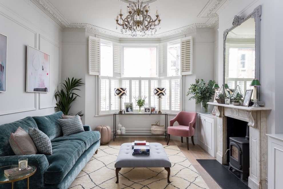 Scandi formal and grey and teal living room in London with white walls, light hardwood flooring, a wood burning stove, no tv and beige floors.