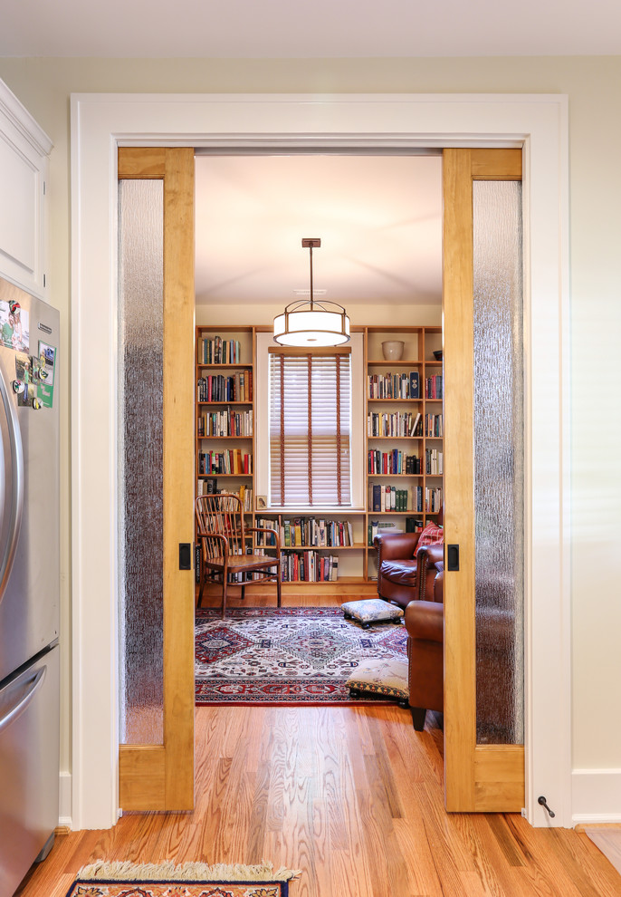 Aménagement d'un petit salon classique fermé avec une bibliothèque ou un coin lecture, un mur beige et un sol en bois brun.