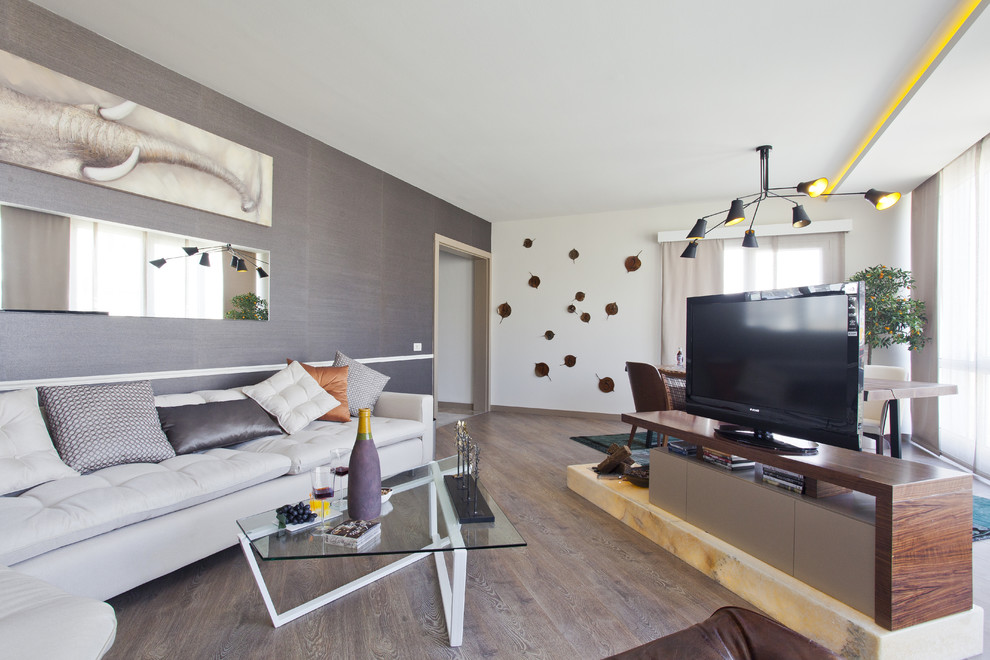 Idee per un soggiorno minimal con pareti grigie e TV autoportante