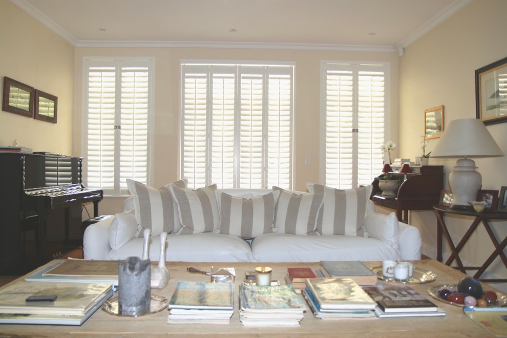 Foto di un soggiorno design aperto con pareti bianche, pavimento in terracotta, stufa a legna e cornice del camino in mattoni