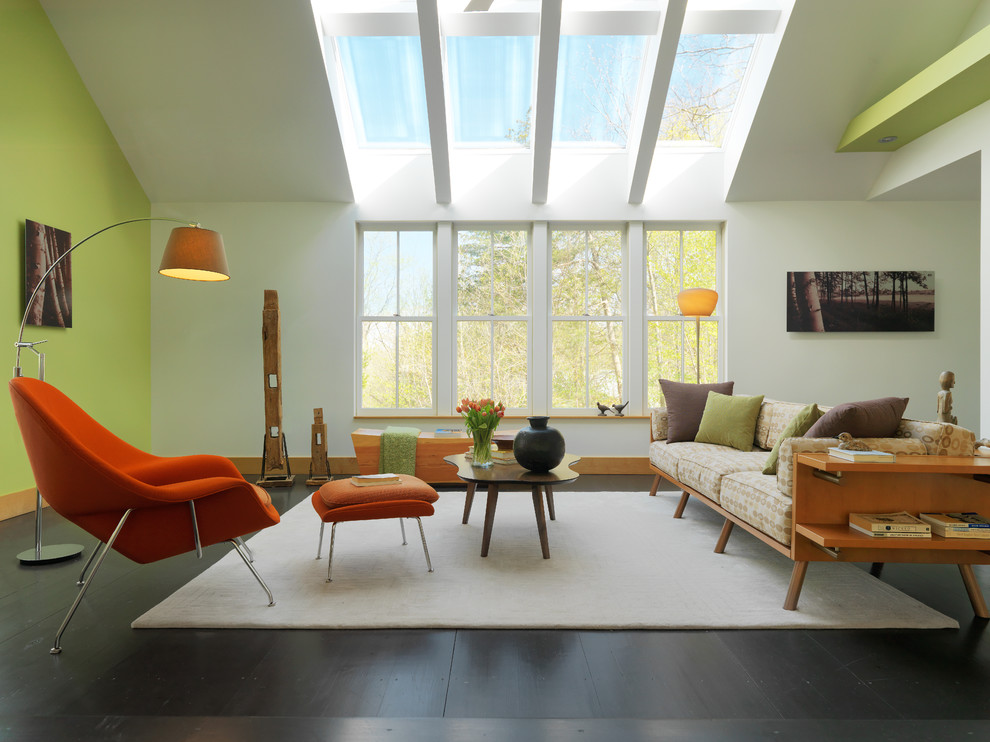 На фото: двухуровневая гостиная комната в современном стиле с зелеными стенами, темным паркетным полом и акцентной стеной без камина с