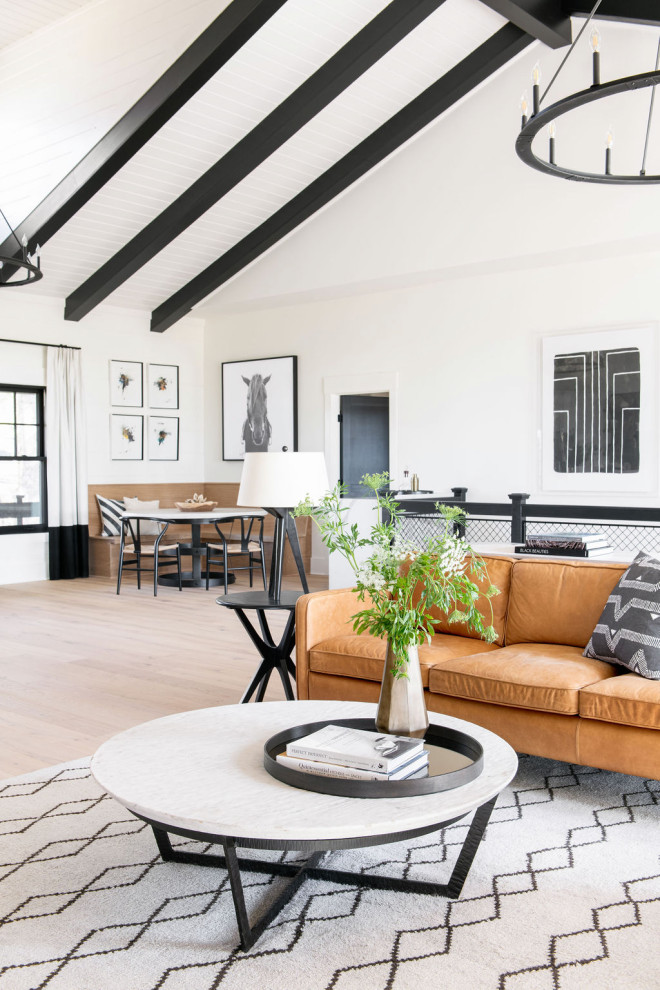Immagine di un grande soggiorno country aperto con pareti bianche, parquet chiaro, pavimento marrone, soffitto a volta e pareti in legno
