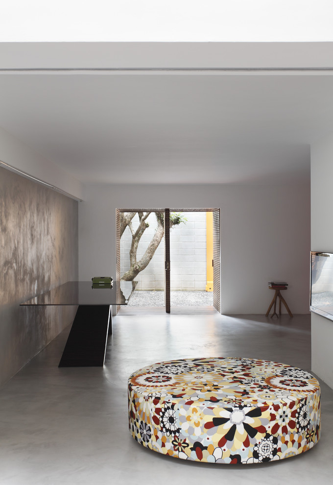 Foto de salón abierto moderno con paredes blancas y suelo de cemento