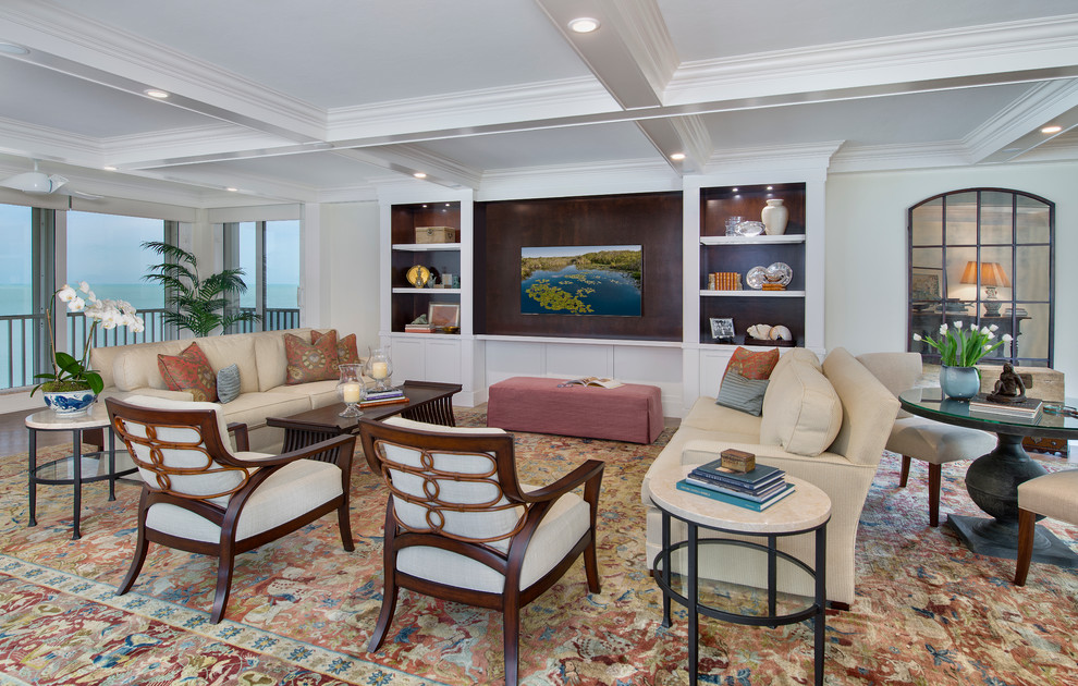 Immagine di un soggiorno classico di medie dimensioni e aperto con pareti beige, pavimento in gres porcellanato e parete attrezzata