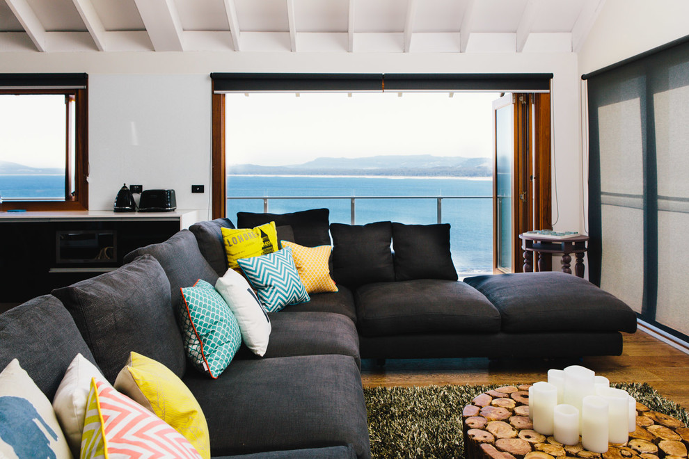 Esempio di un grande soggiorno stile marinaro stile loft con pareti bianche e pavimento in legno massello medio