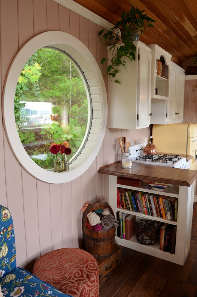 Esempio di un piccolo soggiorno stile americano aperto con pareti beige, pavimento in legno massello medio e nessuna TV