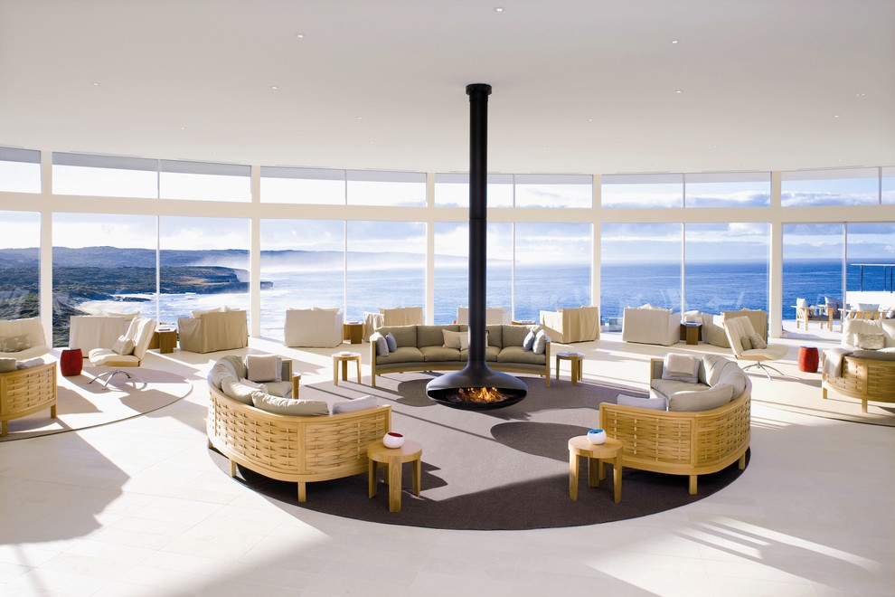 Стильный дизайн: огромная открытая гостиная комната в современном стиле с подвесным камином и полом из керамической плитки - последний тренд