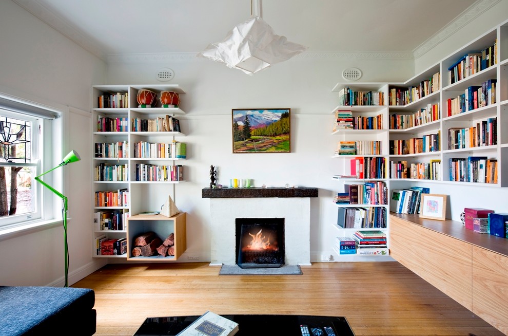 Inspiration pour un salon design de taille moyenne avec un mur blanc, un sol en bois brun, une cheminée standard et un téléviseur indépendant.