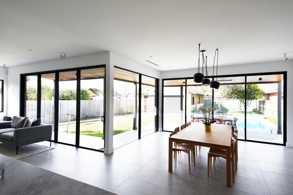 Photo of a medium sized contemporary dining room in Sydney with white walls, porcelain flooring and grey floors.
