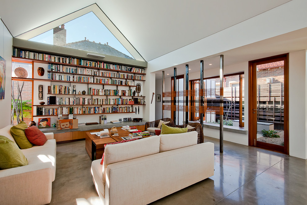 Immagine di un soggiorno minimal con libreria, pareti bianche, nessun camino e nessuna TV