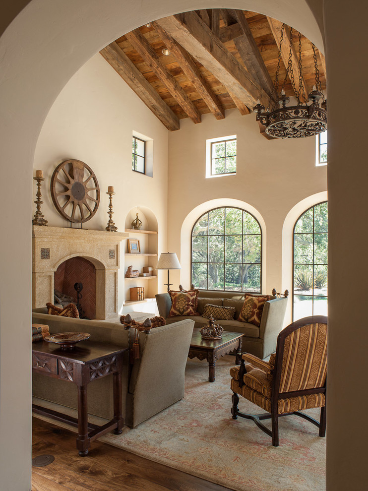 This is an example of a large mediterranean formal open plan living room in Other with beige walls, dark hardwood flooring, a standard fireplace, a stone fireplace surround, no tv and brown floors.