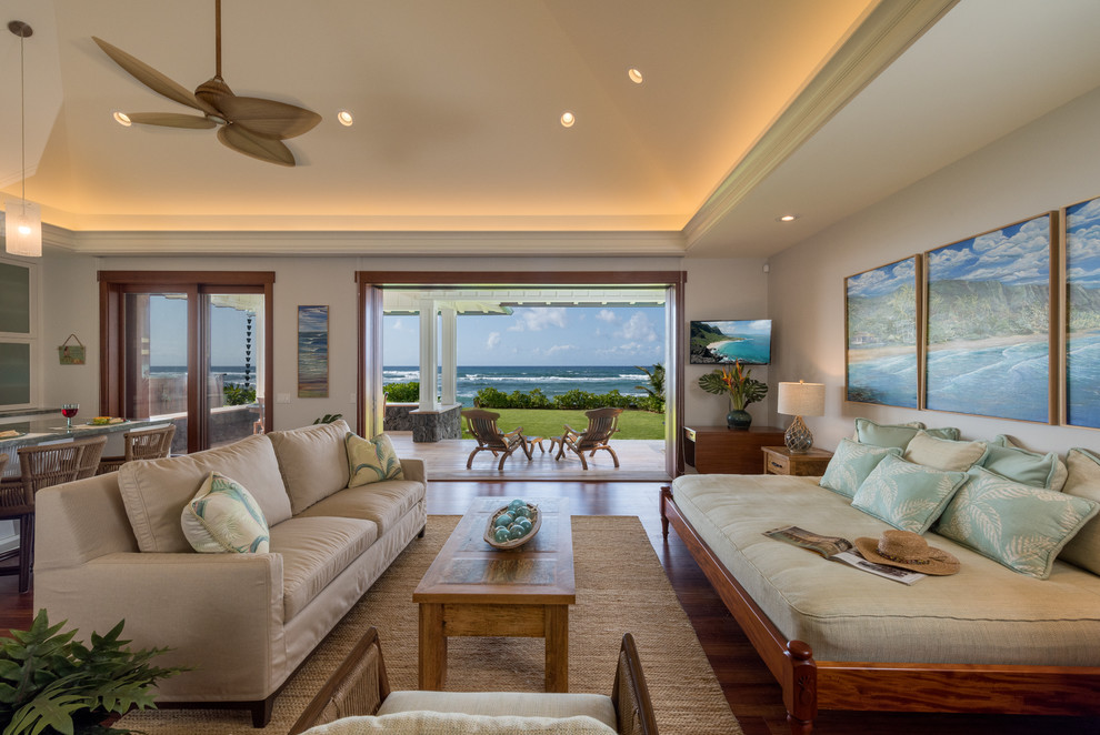 Offenes Maritimes Wohnzimmer mit weißer Wandfarbe, Vinylboden, TV-Wand und braunem Boden in Hawaii