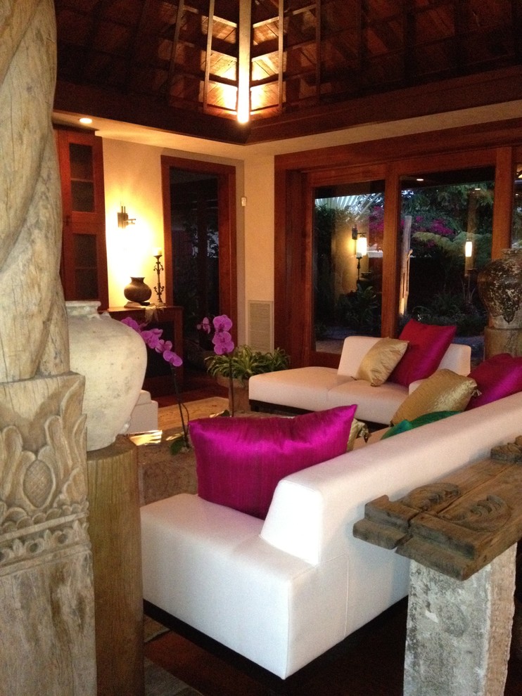 Ispirazione per un soggiorno tropicale di medie dimensioni e chiuso con pareti beige e pavimento in legno massello medio