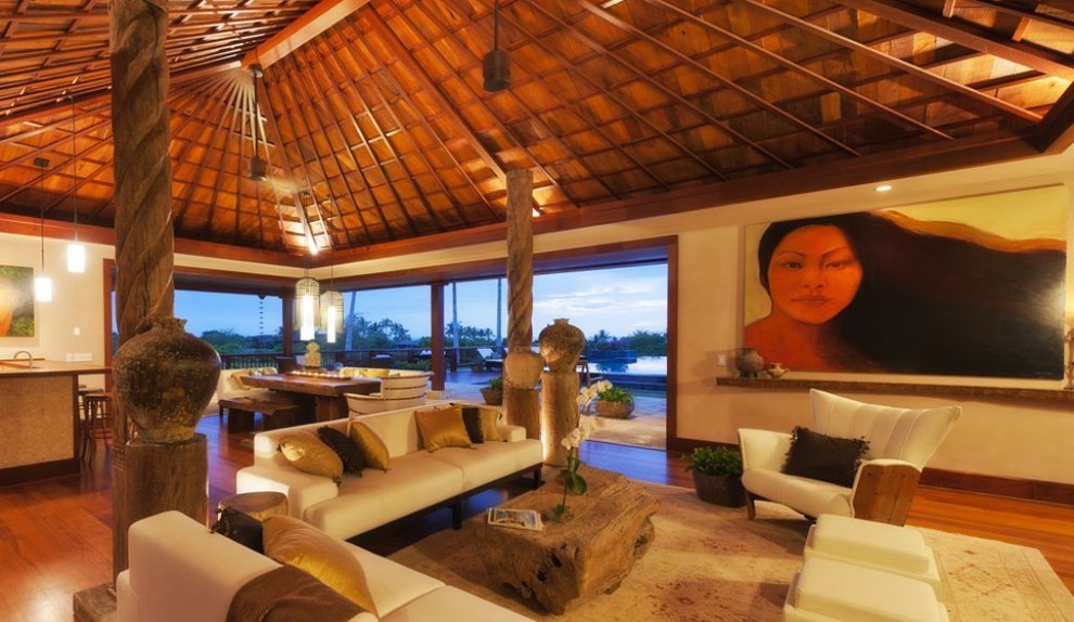 Diseño de salón abierto tropical grande sin chimenea y televisor con paredes beige y suelo de madera en tonos medios