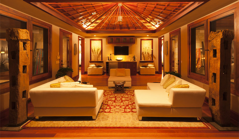 Idee per un grande soggiorno tropicale chiuso con pareti beige, pavimento in legno massello medio, nessun camino e TV a parete