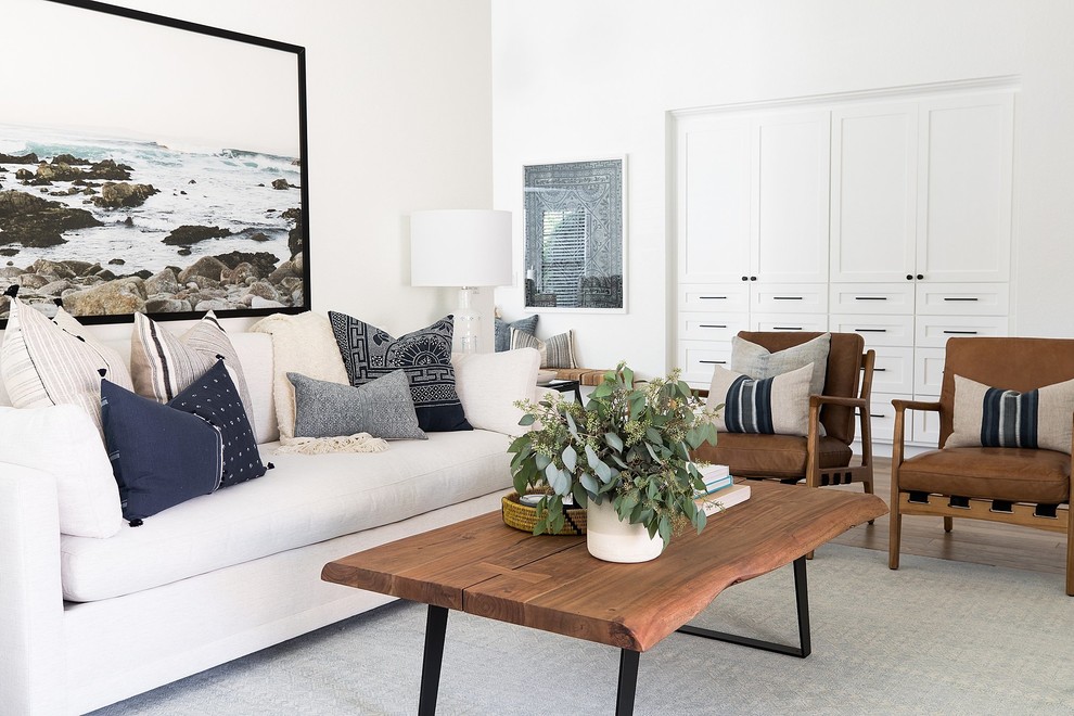 This is an example of a rural formal enclosed living room in Sacramento with white walls, medium hardwood flooring, brown floors and feature lighting.