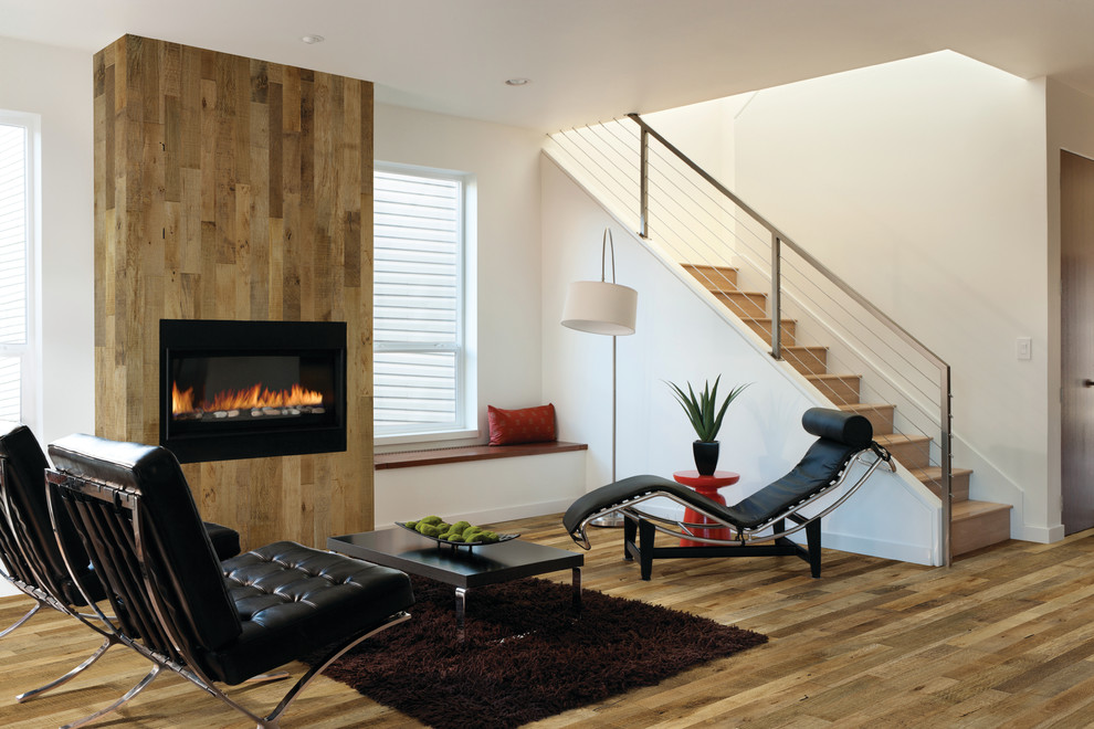 Exemple d'un grand salon tendance ouvert avec un mur multicolore, un sol en bois brun, une cheminée standard, un manteau de cheminée en bois et aucun téléviseur.