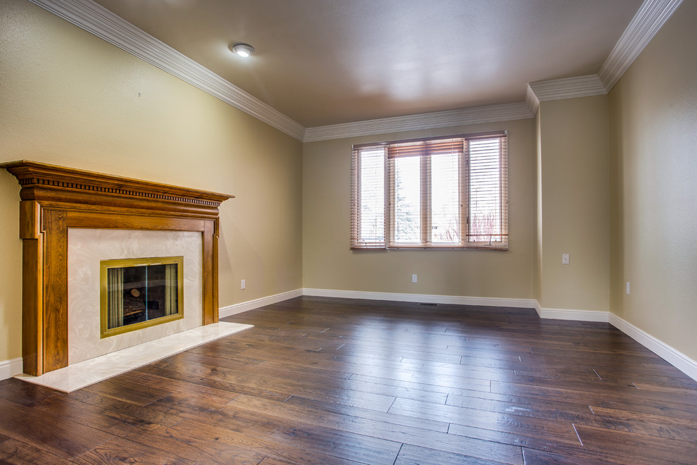 Mittelgroßes, Abgetrenntes Klassisches Wohnzimmer mit grüner Wandfarbe, braunem Holzboden, Kamin und gefliester Kaminumrandung in Denver