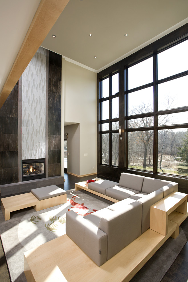 Imagen de salón abierto actual grande sin televisor con paredes beige, chimenea de doble cara, suelo de madera oscura y alfombra