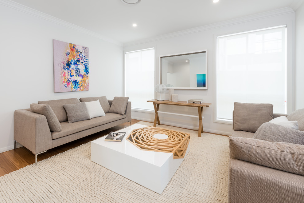 Idee per un soggiorno contemporaneo con sala formale, pareti bianche e pavimento in legno massello medio