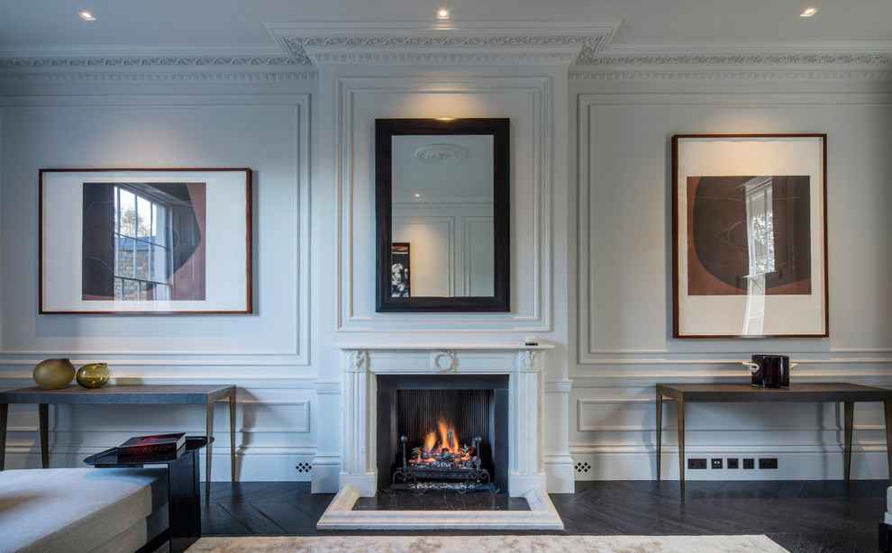 ロンドンにあるラグジュアリーな広いトラディショナルスタイルのおしゃれなリビング (白い壁、濃色無垢フローリング、標準型暖炉、石材の暖炉まわり、テレビなし) の写真