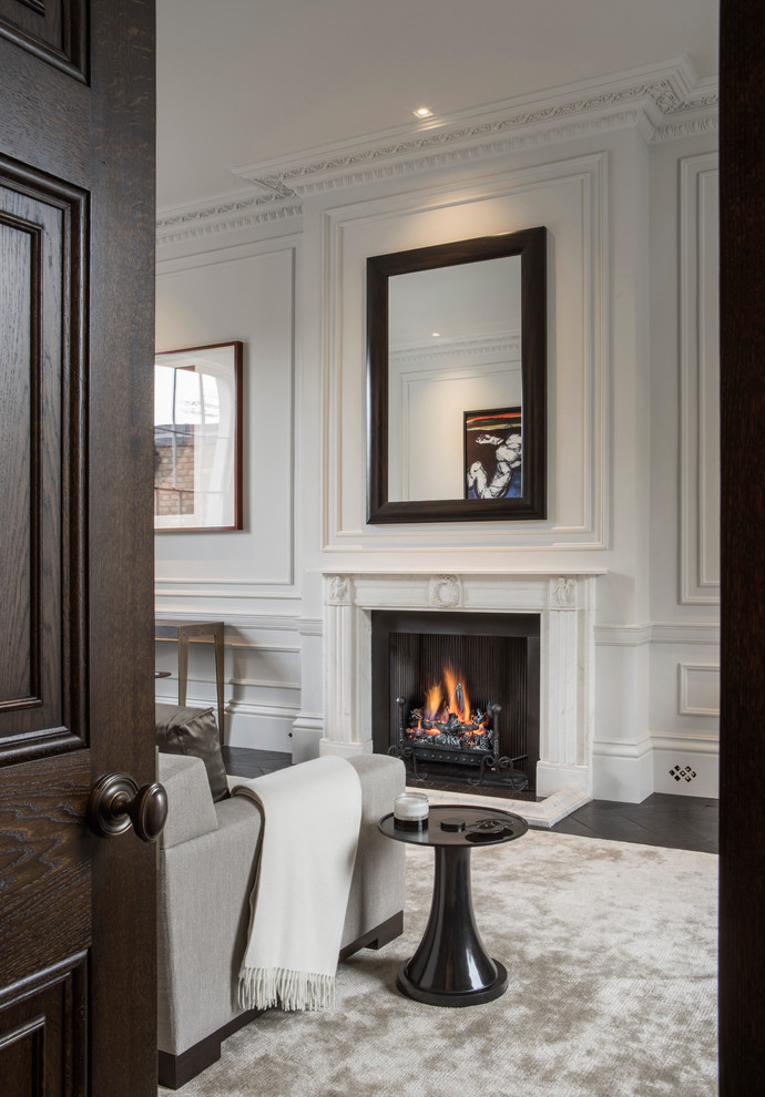 ロンドンにあるラグジュアリーな広いトラディショナルスタイルのおしゃれなリビング (白い壁、濃色無垢フローリング、標準型暖炉、テレビなし、石材の暖炉まわり) の写真