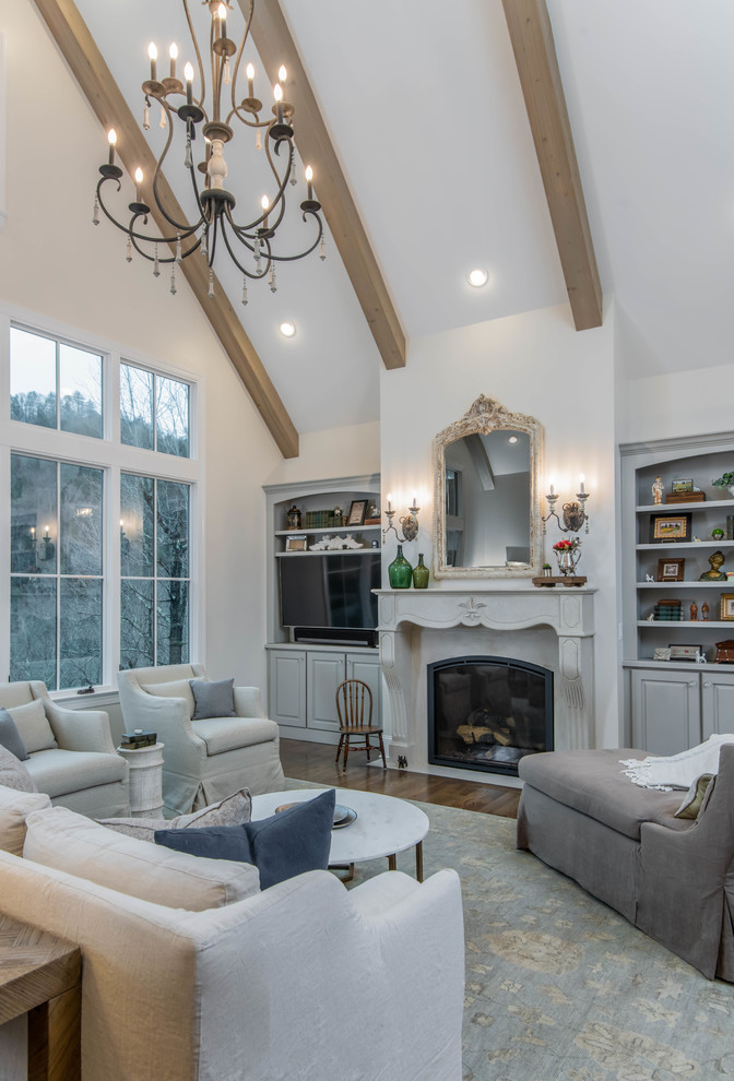 Inspiration for a mid-sized timeless formal and open concept dark wood floor and brown floor living room remodel in Other with beige walls, a standard fireplace, a wood fireplace surround and a wall-mounted tv
