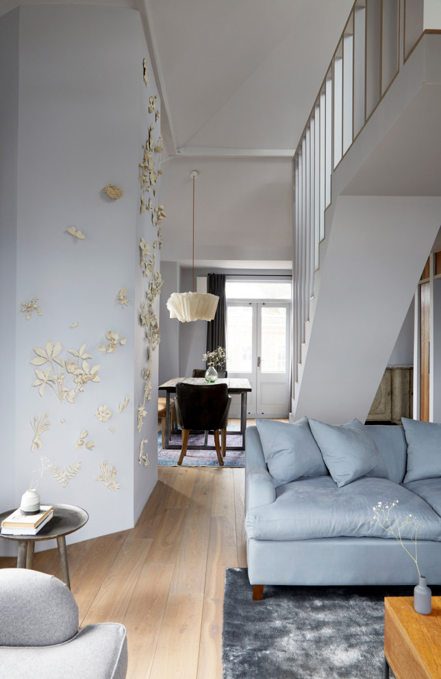 Foto di un grande soggiorno rustico aperto con pareti blu, pavimento in legno massello medio e TV a parete