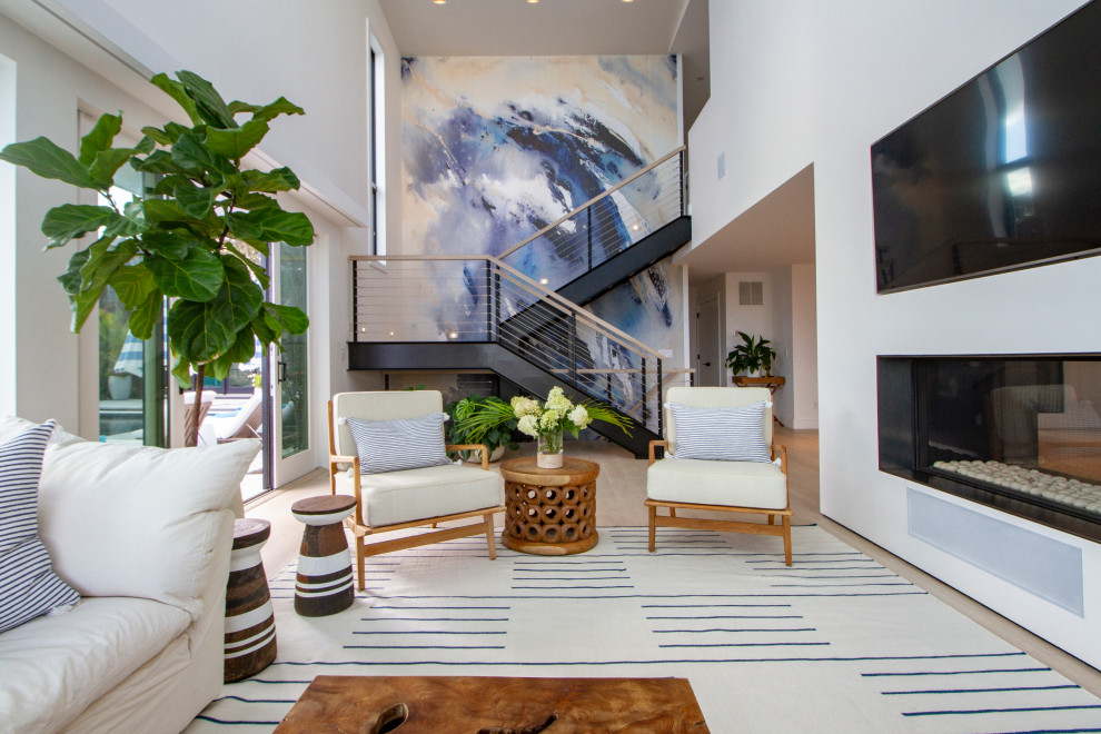 Offenes Maritimes Wohnzimmer mit weißer Wandfarbe, hellem Holzboden, Gaskamin, TV-Wand und beigem Boden in New York
