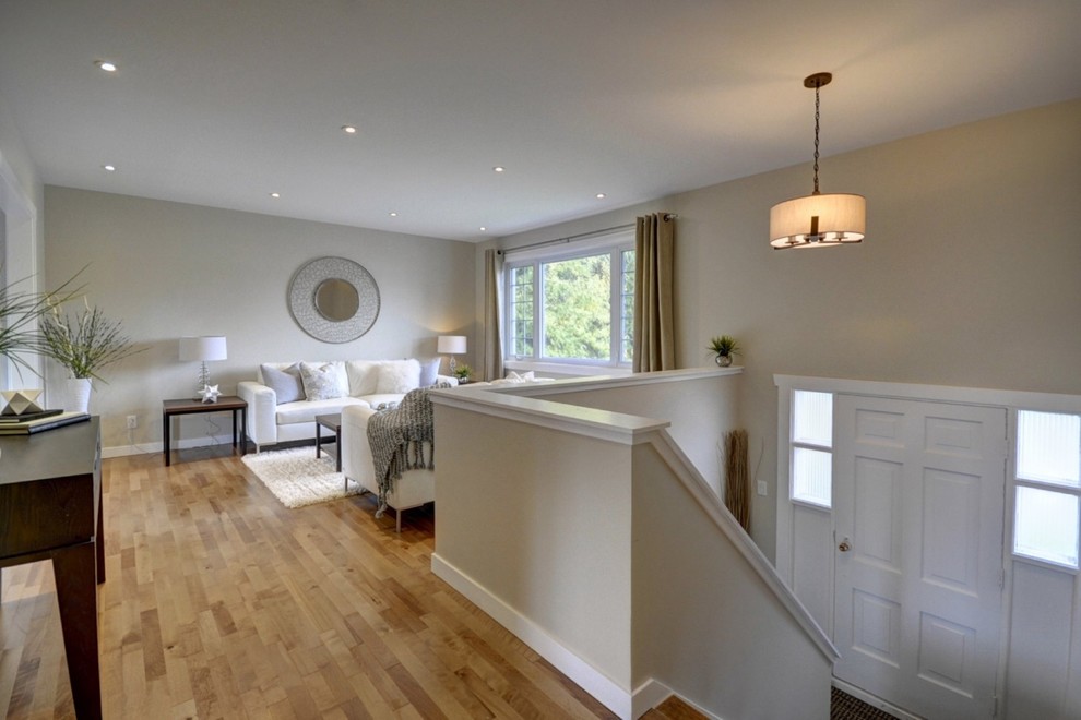 Mittelgroßes, Offenes Modernes Wohnzimmer mit beiger Wandfarbe und braunem Holzboden in Montreal