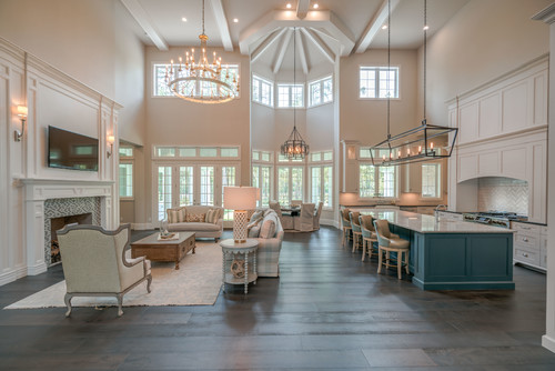grand living room with high ceilings, windows, and an island