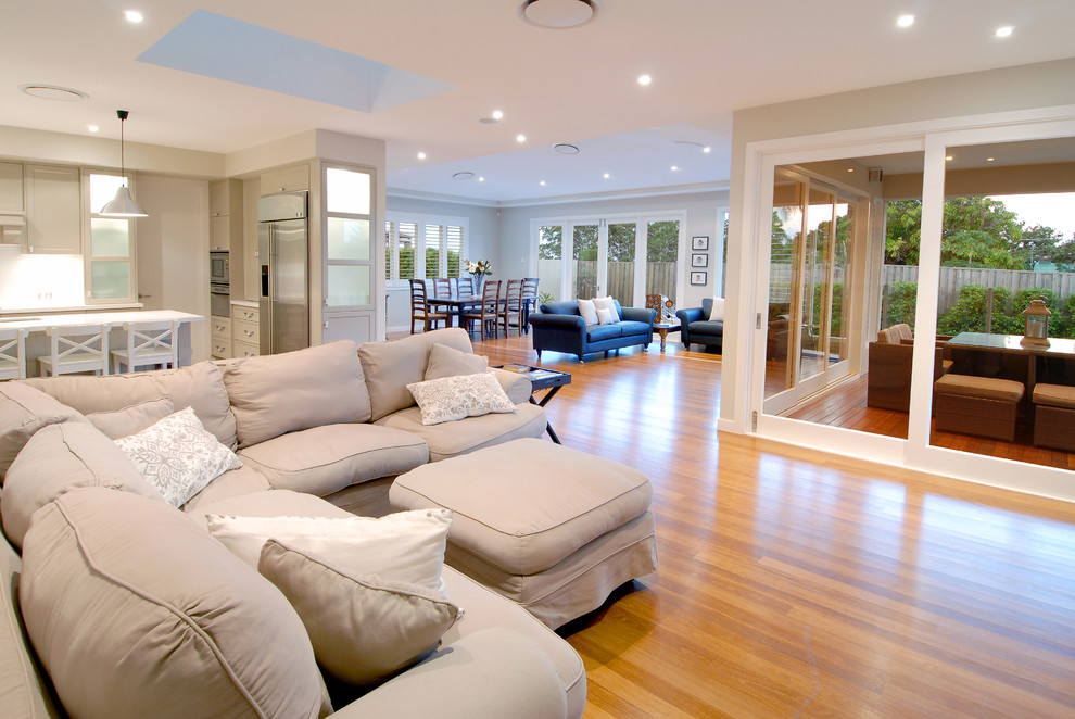 Immagine di un grande soggiorno tradizionale aperto con pareti beige e parquet chiaro