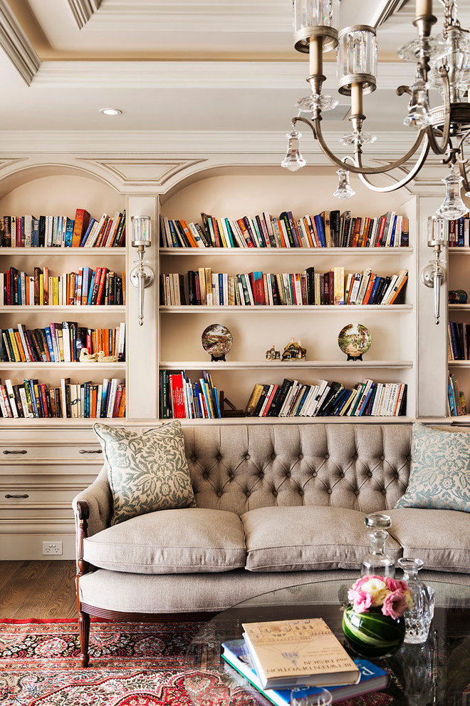 Immagine di un soggiorno chic di medie dimensioni e aperto con libreria, pareti beige e parquet scuro