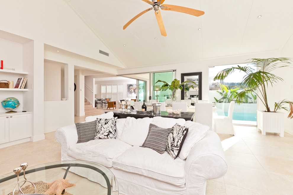 Стильный дизайн: открытая гостиная комната среднего размера в морском стиле с белыми стенами и полом из известняка - последний тренд