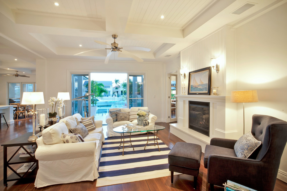 Foto di un soggiorno stile marinaro aperto con pareti bianche e pavimento in legno massello medio