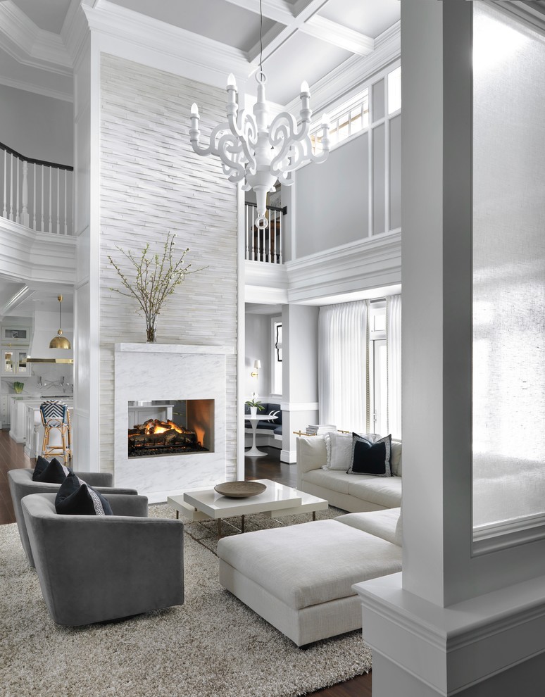 Стильный дизайн: большая открытая гостиная комната в стиле неоклассика (современная классика) с серыми стенами, темным паркетным полом, двусторонним камином, коричневым полом и фасадом камина из камня - последний тренд