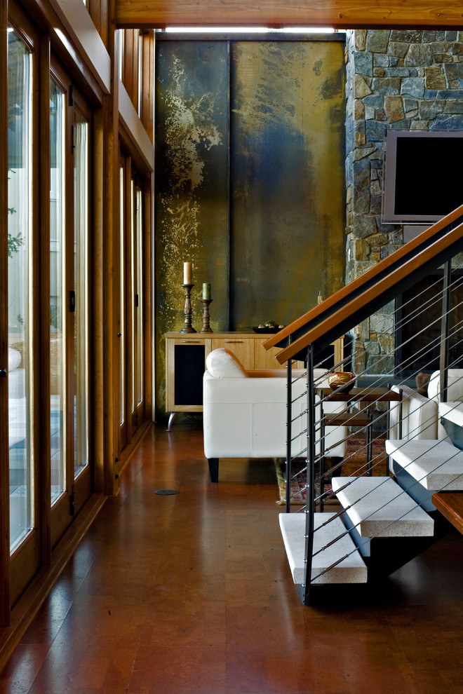Esempio di un soggiorno minimalista con cornice del camino in pietra e TV a parete