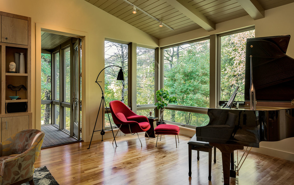 Cette image montre un salon design avec un mur vert et un sol en bois brun.