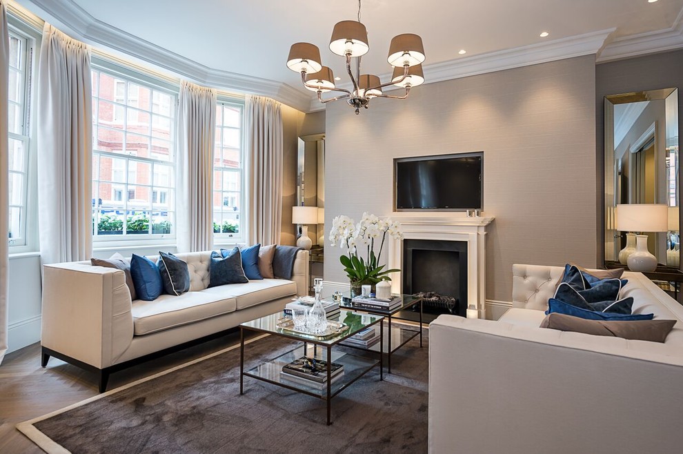 Photo of a large contemporary formal open plan living room in London with grey walls, medium hardwood flooring, a standard fireplace, a built-in media unit and brown floors.