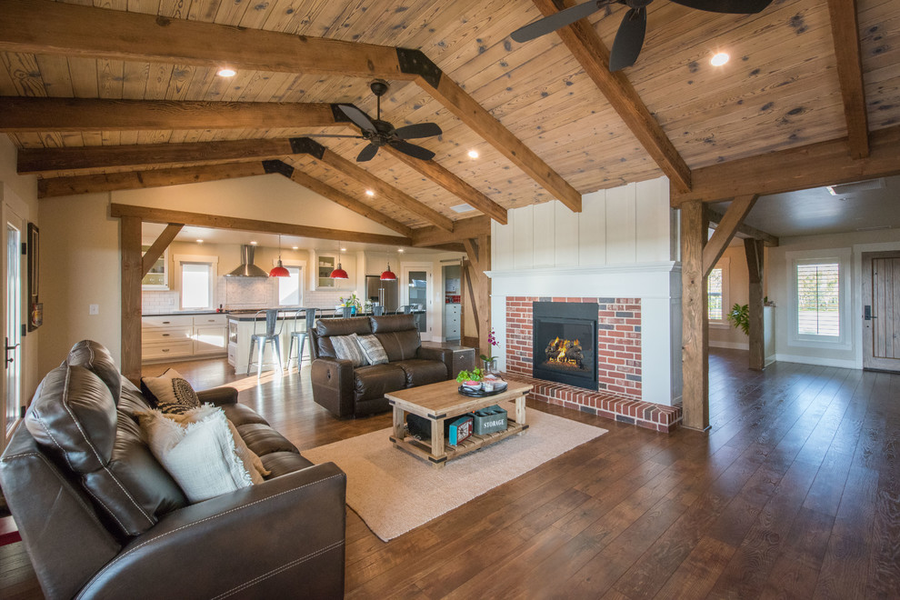 Inspiration for a farmhouse open concept dark wood floor and brown floor living room remodel in Other with white walls, a standard fireplace and a brick fireplace