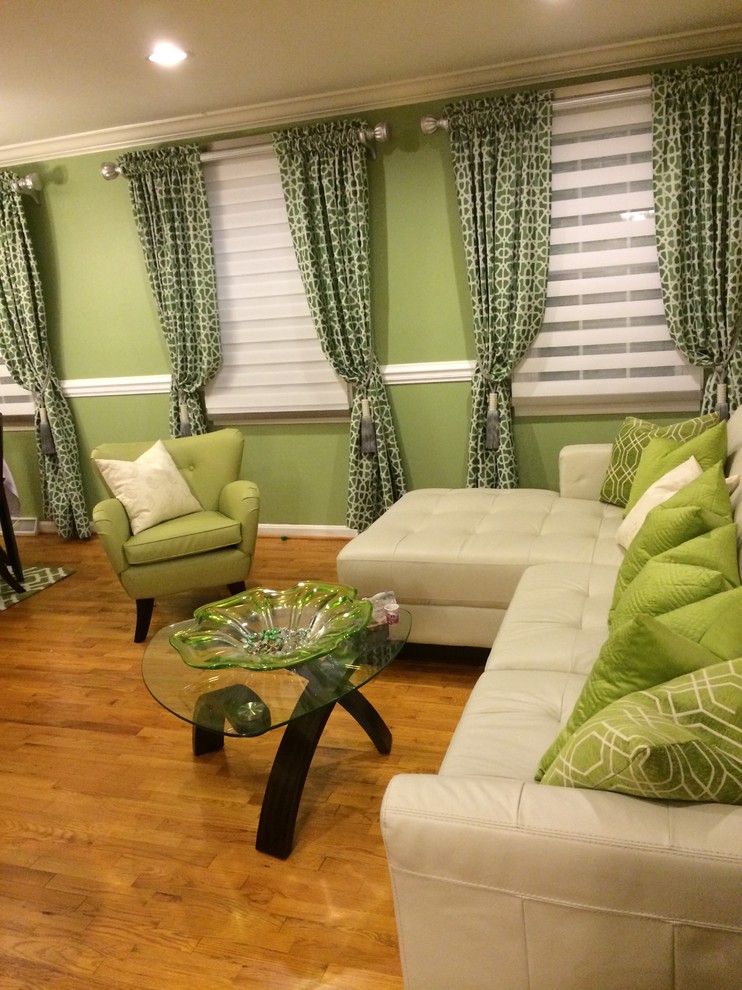Foto på ett funkis vardagsrum, med gröna väggar och ljust trägolv