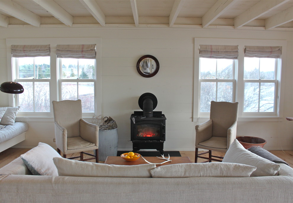 Country living room photo in Portland Maine with white walls and a wood stove