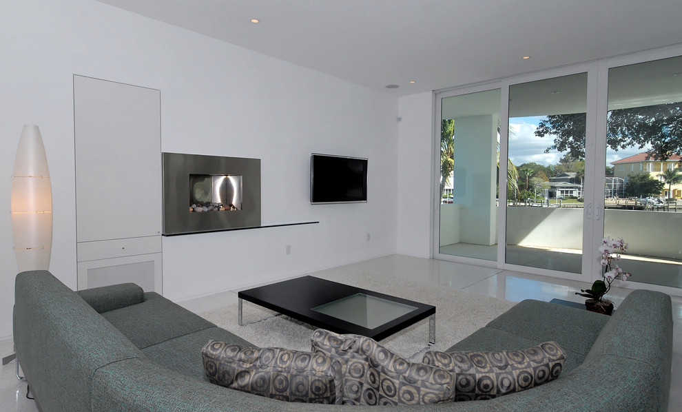 Inredning av ett modernt mellanstort allrum med öppen planlösning, med vita väggar, en spiselkrans i metall och en väggmonterad TV
